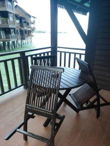 a bench and a chair sitting on a porch at Renovated 2 Bedroom Seavilla for 6pax in Pantai Cenang