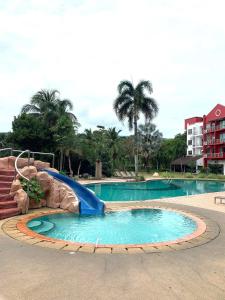 een glijbaan in een zwembad in een resort bij Renovated 2 Bedroom Seavilla for 6pax in Pantai Cenang