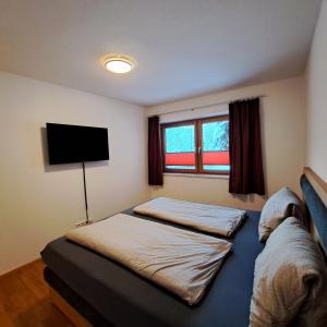 um quarto com 2 camas e uma televisão de ecrã plano em Ferienwohnung Prama em Going