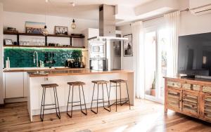 a kitchen with a counter and bar stools at AMARA Family & Surf with Oceanview and Pool in Tarifa