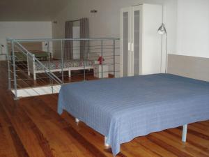 a bedroom with a blue bed and a staircase at Gîte du Tarbésou in Régat