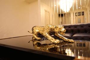 uma estátua de ouro de um leão numa mesa de vidro em LOUVRE HOME em Sevan