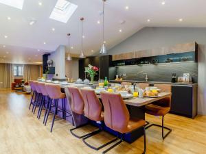 una cocina con una mesa larga con sillas moradas en 3 Bed in Mundesley 86635 en Mundesley