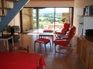 uma sala de estar com cadeiras vermelhas e uma mesa em Gîte du Tarbésou em Régat