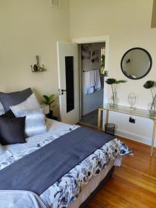 um quarto com uma cama grande e um espelho em One Three Nine On Roberts em Pietermaritzburg