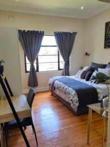 um quarto com uma cama, uma secretária e uma janela em One Three Nine On Roberts em Pietermaritzburg