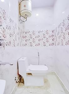 Baño blanco con aseo y lavamanos en Stay with Palace Near- Anand Vihar Station, en Nueva Delhi