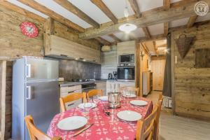 a dining room with a table and a refrigerator at LA DENT PARRACHEE in Termignon