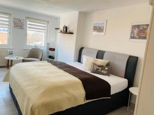 a bedroom with a bed and a chair at Pension Wunderbar in Naumburg