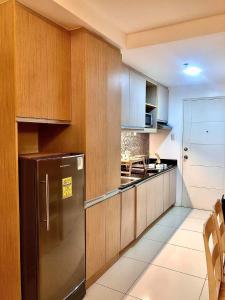 a kitchen with wooden cabinets and a stainless steel refrigerator at Wind Suites in Tagaytay