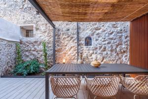 a table and chairs on a patio with a stone wall at VALL PETIT in Valldemossa