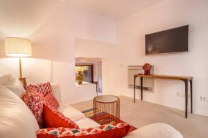 a living room with a couch and a tv on the wall at VALL PETIT in Valldemossa