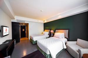 Postel nebo postele na pokoji v ubytování Swiss-Belhotel Rainforest