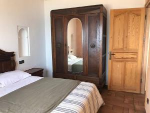 a bedroom with a bed and a large wooden cabinet at Asilah beach Apartment seaview in Asilah