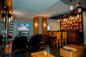 - un bar avec des chaises, une table et une télévision dans l'établissement Casi Verde Guest House, à Panglao