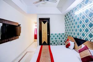 1 dormitorio con 1 cama, TV y puerta en Stay with Palace Near- Anand Vihar Station, en Nueva Delhi