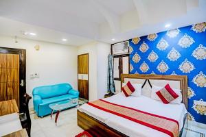 1 dormitorio con 1 cama y 1 silla azul en Stay with Palace Near- Anand Vihar Station, en Nueva Delhi