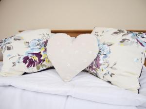 poduszkę na łóżku z kwiatowymi poduszkami w obiekcie 1 bed in Berrynarbor 43641 w mieście Berrynarbor