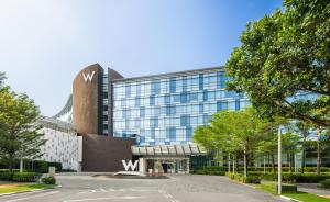 um grande edifício de vidro com uma placa em frente em W Singapore - Sentosa Cove, Newly Renovated em Singapura