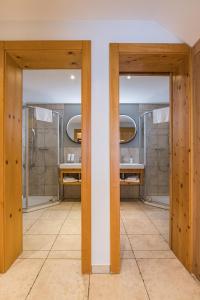 ein Badezimmer mit zwei Waschbecken und zwei Spiegeln in der Unterkunft Chalet Lea in Zermatt