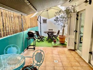 patio z parasolem, stołem i krzesłami w obiekcie Marina Apartmets w Salonikach
