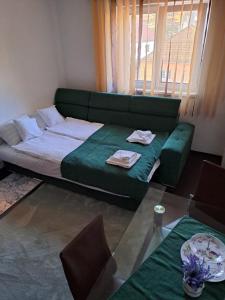 een woonkamer met een groene bank en een tafel bij Apartament Borsec in Borsec
