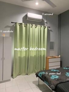 a bedroom with a green shower curtain and a bed at homestayfidagerik in Gerik