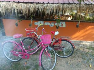 duas bicicletas estacionadas uma ao lado da outra em frente a um edifício em Le Soleil em Kep