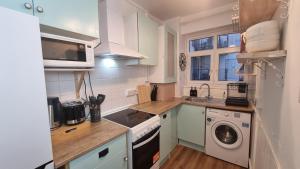 a kitchen with a washer and dryer and a microwave at 3 bed flat O2 arena Dyson house in London