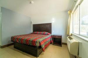 una piccola camera con letto e finestra di Xpress Inn & Extended Stay a Marshall