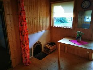 Habitación pequeña con mesa y chimenea en Hide in the nature – cozy lakeside saunacottage, en Rannaküla