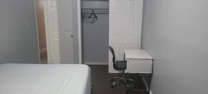 a bedroom with a bed and a desk and a chair at Room in a Beach House with Queen bed in a landlord hosted three bedroom apartment in Edgemere