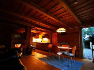 a living room with a table and chairs and a fireplace at Hide in the nature – cozy lakeside saunacottage in Rannaküla