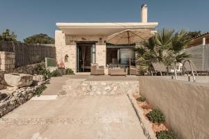 a house with a patio with an umbrella at Anemos in Koríthion