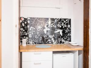 a bathroom counter with a black and white wallpaper at Apart 3b in Krakow