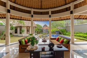 an outdoor living room with a couch and a table at The Mutiara Jimbaran Boutique Villas in Jimbaran