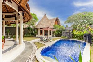 a villa with a swimming pool and a house at The Mutiara Jimbaran Boutique Villas in Jimbaran