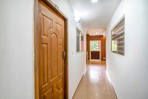 FabHotel Abrigo Residency في مونار: مدخل مع باب خشبي في منزل