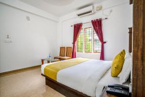 a bedroom with a large bed and a window at FabHotel Abrigo Residency in Munnar