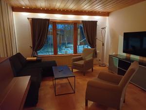 a living room with a couch and chairs and a television at Kiruna accommodation Läraregatan 19 b in Kiruna