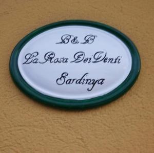 un plato colgando de una pared con escritura en él en B&B La Rosa Dei Venti Sardinya, en Sinnai