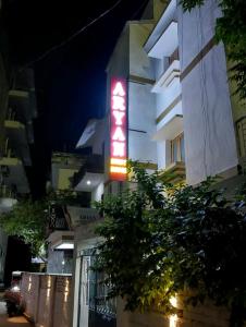 een bord aan de zijkant van een gebouw 's nachts bij Aryan guest house in Bodh Gaya