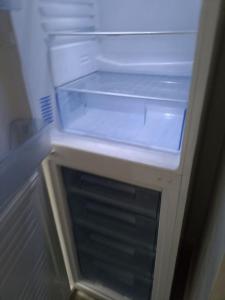 an empty refrigerator with its door open and its drawer at Jamal in Montélimar