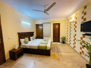a bedroom with a bed and a flat screen tv at Fortune Home Service Apartment 4Bhk,D-36, Saket in New Delhi