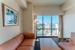 a living room with a couch and a large window at Hotel Atollemerald Miyakojima in Miyako-jima