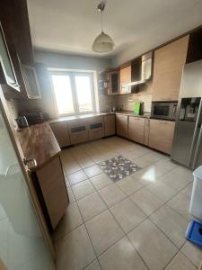a large kitchen with a tile floor and a window at WhiteFort apartment in Almaty
