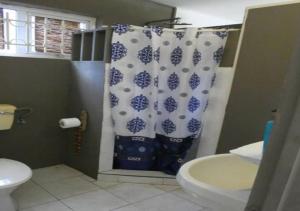 a bathroom with a toilet and a shower curtain at Bikini in Pointe d'Esny