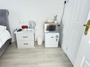 a small kitchen with a microwave and a refrigerator at Peaceful time in Trowbridge