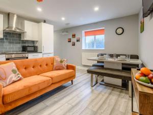 a living room with an orange couch and a kitchen at 2 bed property in Hornsea 85723 in Hornsea