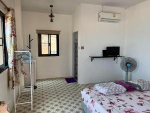 a bedroom with a bed and a window and a fan at grandmabalcony in Prachuap Khiri Khan